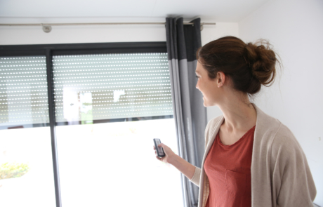 Woman using remote control to open electric shutter